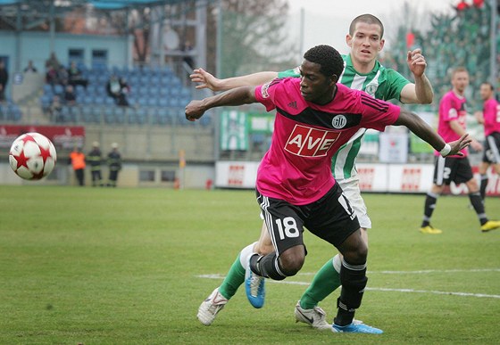 eskobudjovický záloník Fernando Hudson (v popedí) pospíchá za míem ped Davidem Bartkem z Bohemians.