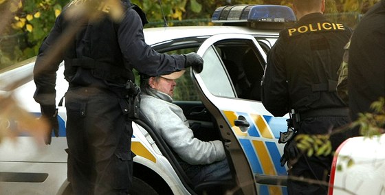 Policisté odváejí k výslechu Otakara T., který je podezelý z vrady devítileté Aniky. (24. íjna 2010)