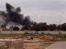Z bombardovaného letit na pedmstí Benghází stoupá kou (17. bezna 2011)