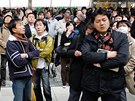Lidé na tokijském nádraí sledují obrazovky s informacemi o zemtesení, které postihlo východ zem. (11. bezna 2011)