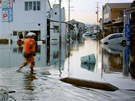 Mu se brodí zaplavenou ulici v japonském Iwaki. (11. bezna 2011)