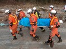 Japontí záchranái nesou tlo jedné z obtí z japonské vesnice Saito. (14. bezna 2011)