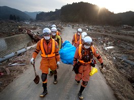 Záchranáři nesou tělo jedné z obětí v severojaponské vesnici Saito. (14. března 2011)