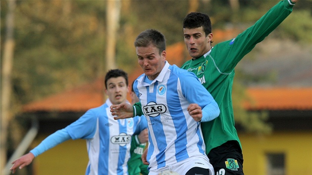 Pavel Simr ze Sezimova Ústí si zpracovává mí�, na záda se mu lepí sokolovský Juraj Chupá�.