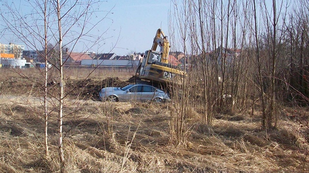 Nepozorný bagrista na stavb v Plzni zniil luxusní mercedes