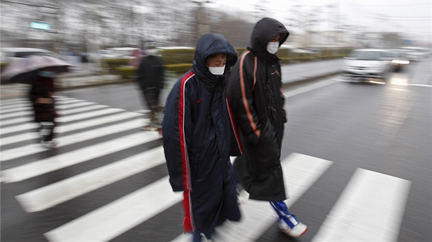 Japonci, kteí byli v okolí 20 kilometr po explozích ve Fukuim, kráí do centra, kde jim zmí výi ozáení (15. bezna 2011)