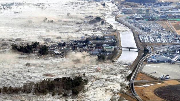 Ničivá přívalová vlna se valí na japonské pobřežní město Iwanuma. (11. března 2011)