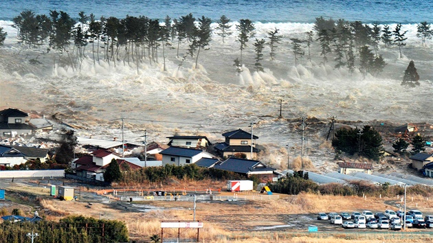 Ničivá přívalová vlna se valí na japonské pobřežní město Natori. (11. března 2011)