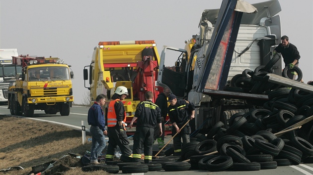 Z pevráceného kamionu u Nového Msta se vysypaly pneumatiky. (15. bezna 2011)