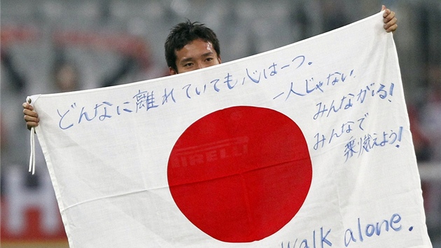 VZKAZ DOM. Japonec Yuto Nagatomo podporuje svou vlast v tkých asech alespo vzkazem po vítzném utkání nad Bayernem Mnichov.