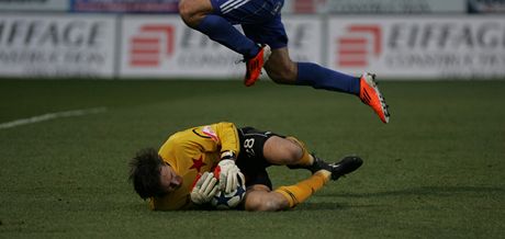 DRÍM A NEPUSTÍM. Gólman Slavie Martin Vaniak kryje mí v náruí ped jedním z hrá Olomouce.