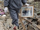 Toii Obata si nese rodinnou fotografii, kterou zachránil ze svého domu v Natori, který zdemolovalo zemtesení a tsunami (20. bezna 2011)