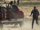 Libyjtí rebelové utíkají ped stelami z minomet Kaddáfího jednotek nedaleko msta Adedábíja (23. bezna 2011)