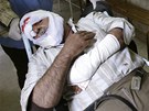 Zdravotník veze mue zranného pi zásahu bezpenostních jednotek vi protivládním demonstrantm (27. bezna 2011)