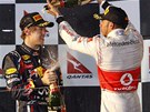 Sebastian Vettel (vlevo) schytává sprku ampaského od Lewise Hamiltona. Red Bull Robem Marshallem .