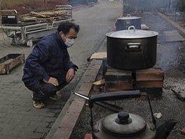 Japonec va jdlo nedaleko nemocnice ve mst Onagava, kter zdevastovalo tsunami (25. bezna 2011)