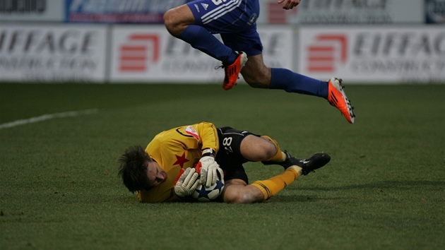 DR�ÍM A NEPUSTÍM. Gólman Slavie Martin Vaniak kryje mí� v náru�í p�ed jedním z hrá�� Olomouce.