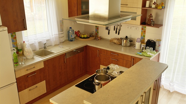 Kuchyská linka byla vyrobena z laminovaných MDF desek. Prostor pro vaení vymezuje ostrovní varné centrum s malým barovým pultem. Zdroj: www.mujdum.cz