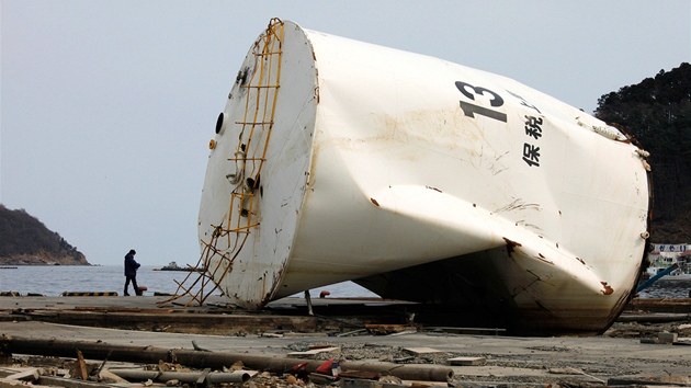 Mu prochází troskami znieného japonského msta Onagawa. (30. bezna 2011)