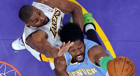 Brazilský basketbalista Nene (vpravo) z Denveru se snaí prosadit pes bránícího  Andrewa Bynuma z Los Angeles Lakers. 