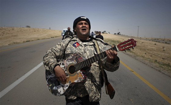 Hrdino, cos dlal za války? Libyjský rebel si vykrauje s kytarou  u msta Briga (5. dubna 2011)