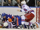 Radek Martnek z NY Islanders (v modrm) drt Mariana Gborka. Tomu spch na pomoc spoluhr z NY Rangers Ryan Callahan.