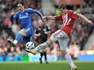 Odkopává obránce Stoke Robert Huth, blokuje ho útoník Chelsea Fernando Torres.