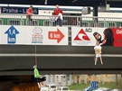Zamstnanci Sazky odstraují figuríny sportovc visících ze elezniního mostu v praských Vysoanech. (4. dubna 2011)