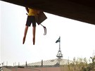 Figuríny sportovc visící ze elezniního mostu v praských Vysoanech. V pozadí je vidt sídlo spolenosti Sazka. (4. dubna 2011)