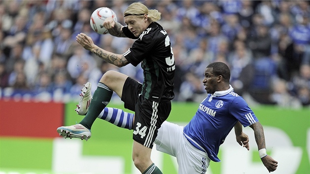 SOUBOJ O MÍ. Jefferson Farfán ze Schalke (vpravo) se natahuje po míi, Simon Kjaer z Wolfsburgu si radji kryje obliej.