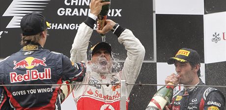 Lewis Hamilton (uprosted) se raduje z triumfu ve Velké cen íny. Vlevo dnes druhý lídr seriálu MS Sebastian Vettel, vpravo tetí Mark Webber.