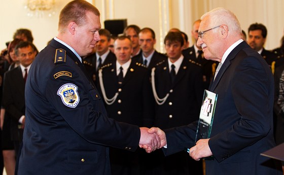 Prezident Václav Klaus oceuje Zlatým záchranáským kíem hasie z Nýan na Plzesku Roberta Kueru a devt jeho koleg, kteí zachránili chlapce uvízlého v hlubokém bahn oputného lomu