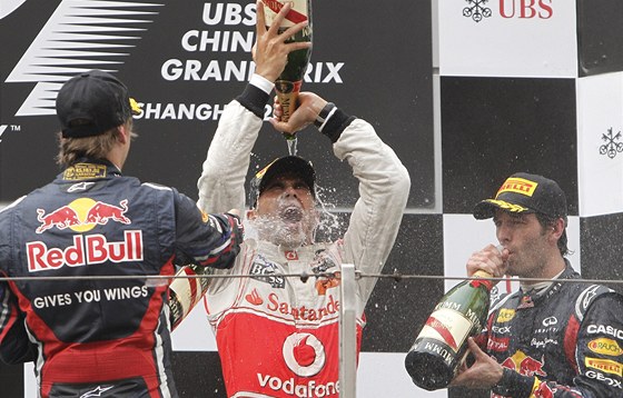 Lewis Hamilton (uprosted) se raduje z triumfu ve Velké cen íny. Vlevo dnes druhý lídr seriálu MS Sebastian Vettel, vpravo tetí Mark Webber.