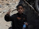 Libyjský chlapec hrd pózuje u trosek Kaddáfího tanku (11. dubna 2011)
