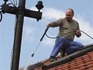 Slavomír Patrman z Chropyn istí stechu svého domu od sazí. (12. dubna 2011)