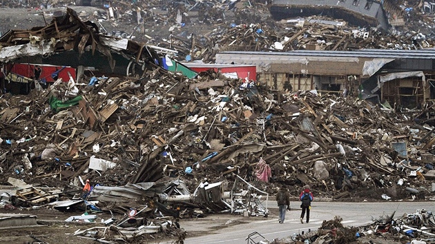 Lidé procházejí zcela znieným mstem Sendaj pesn msíc po devastující vln tsunami. (11. dubna 2011)
