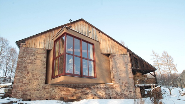 Slam�ný d�m uvnit� zabírá prostor rozlehlé kamenné stodoly jen z�ásti.