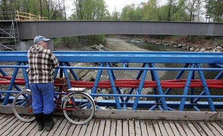 Mu sleduje z provizorní lávky stavbu nového mostu pes Ostravici.