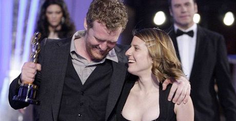 Glen Hansard a Markéta Irglové se radují z Oscara, které ho jim za píse Falling Slowly z filmu Once pedal John Travolta (v pozadí).