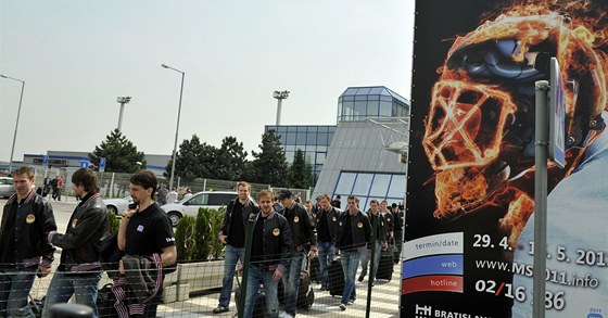 NA MÍST INU. Výprava eských hokejist prochází kolem plakátu mistrovství svta.