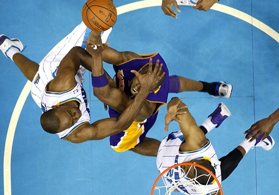  Kobe Bryant (v modrém) z LA Lakers je faulován Carlem Landrym z New Orleans.