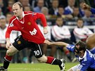 ZÁCHRANNÁ BRZDA. Obránce Metzelder ze Schalke se snaí zastavit útoníka Rooney z United vemi monými zpsoby.