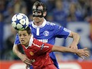 MASKOVANÝ STRÁCE. Obránce Metzelder ze Schalke s ochrannou maskou na oblieji hlídá útoníka Hernándeze z Manchesteru.