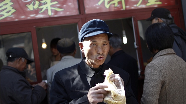 �í�an pojídá sva�inu p�ed obchodem v Pekingu. Ilustra�ní foto