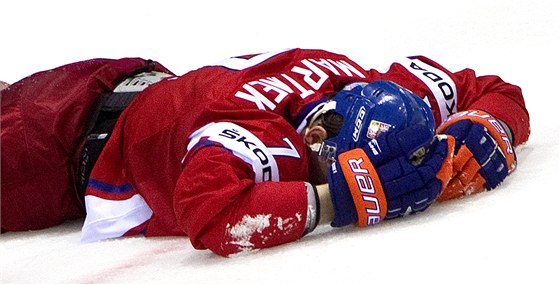 ZRANĚNÍ. Radek Martínek leží na ledě po tvrdém zákroku Lotyše Kuldy.