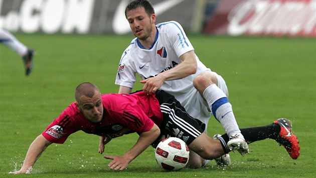 KLOU�E TO. Tomá� Stráský z �eských Bud�jovic padá na mokrý trávník po souboji s ostravským Tomá�em Markem.