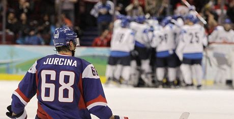 Zatímco hokejisté Finska (v pozadí) slaví zisk bronzových medailí, Slováci se ocitli na kolenou. V tomto pípad konkrétn Milan Jurina.