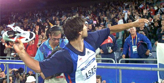 Jan elezný v euforii po vítzném závod v Sydney, který mu pinesl tetí olympijské zlato, hází tretry nadeným divákm.