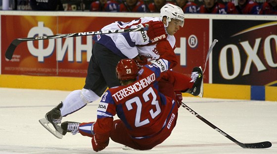 TVRDÁ SRÁŽKA. Ruský hokejista Alexej Těreščenko padá na led po srážce se slovinským soupeřem Robertem Saboličem.