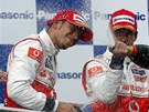 Jenson Button z McLarenu kropí ampaským svého stájového kolegu a vítze Velké ceny Turecka, Lewise Hamiltona.
